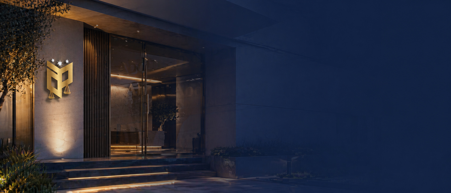 The Amman office entrance of Abdullah & Partners, a law firm in Jordan established in 2000. Illuminated gold logo beside the office doors at twilight.