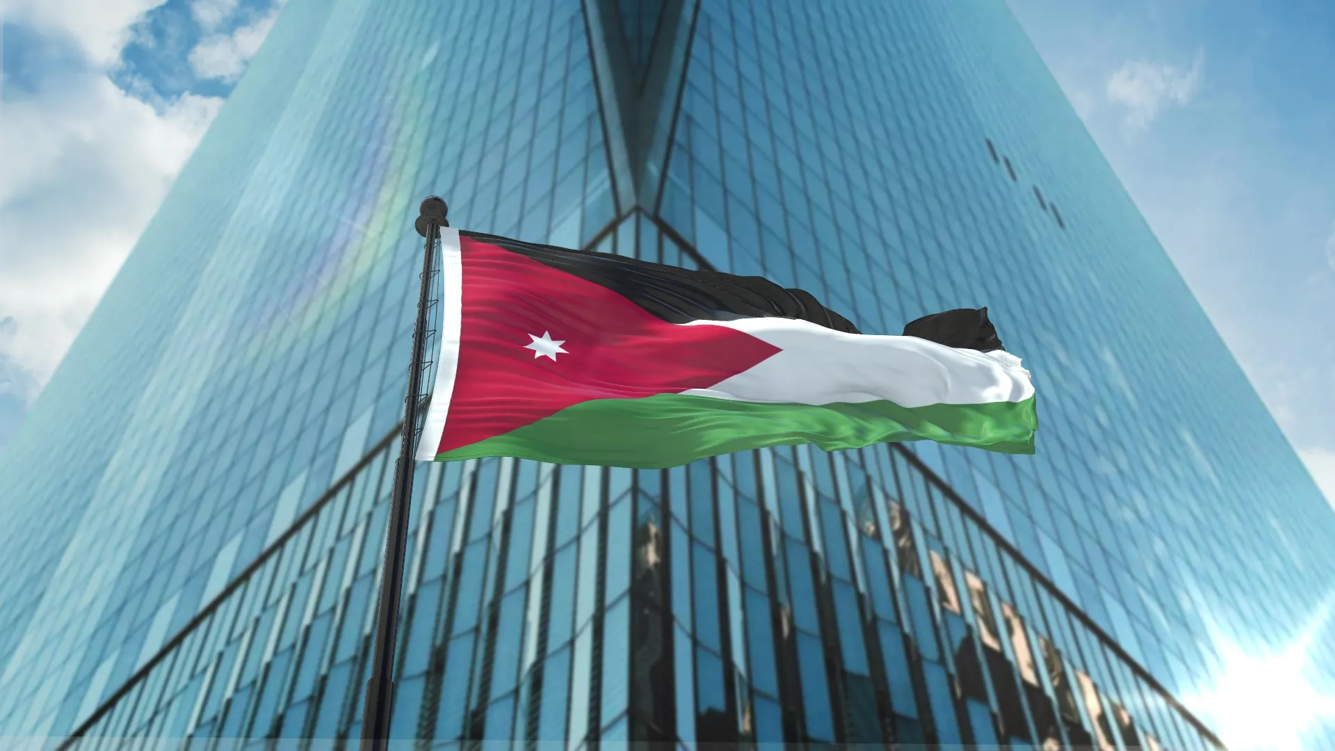 Jordan flag beside a modern glass building, investing in Jordan